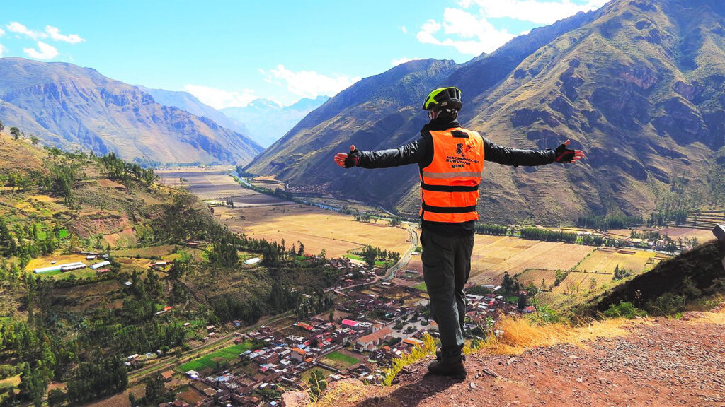Viajero en el Mirador de Taray con vista panorámica del Valle Sagrado de los Incas, rodeado de montañas, campos de cultivo y el río Vilcanota