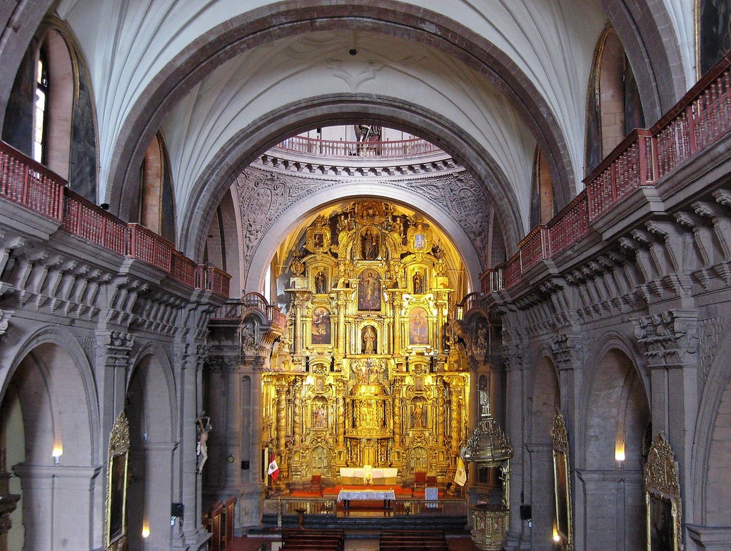 retablo mayor de la iglesia de la compañía de jesús en cusco, altar dorado barroco andino con columnas salomónicas y nichos iluminados