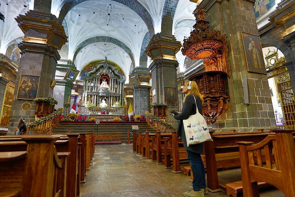 retablo mayor de la catedral del cusco, altar de plata repujada del barroco virreinal con visitantes en el interior del templo
