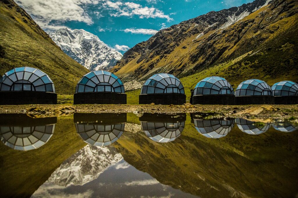 Domos geodésicos de Sky Camp reflejados en laguna frente al nevado Salkantay, un glamping andino de lujo ideal para observar el cielo y la naturaleza de los Andes peruanos