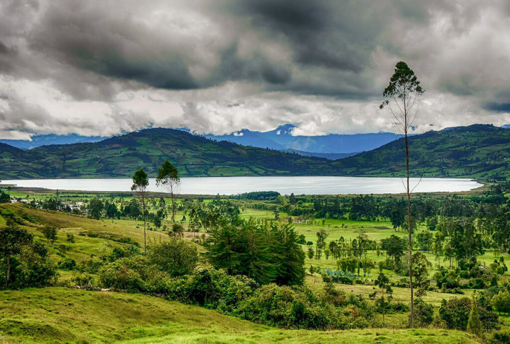 vista panorámica de la laguna de Pomacochas rodeada de bosques nublados en la selva alta del Perú
