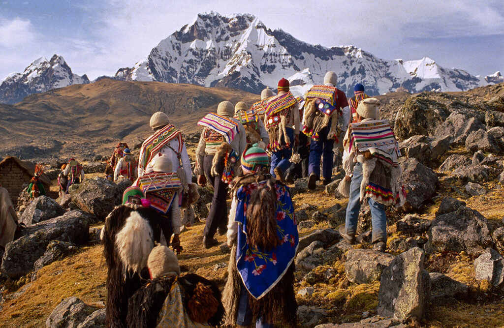 Comuneros del Cusco vestidos con trajes tradicionales andinos ascienden hacia las faldas del Ausangate durante una ceremonia ancestral