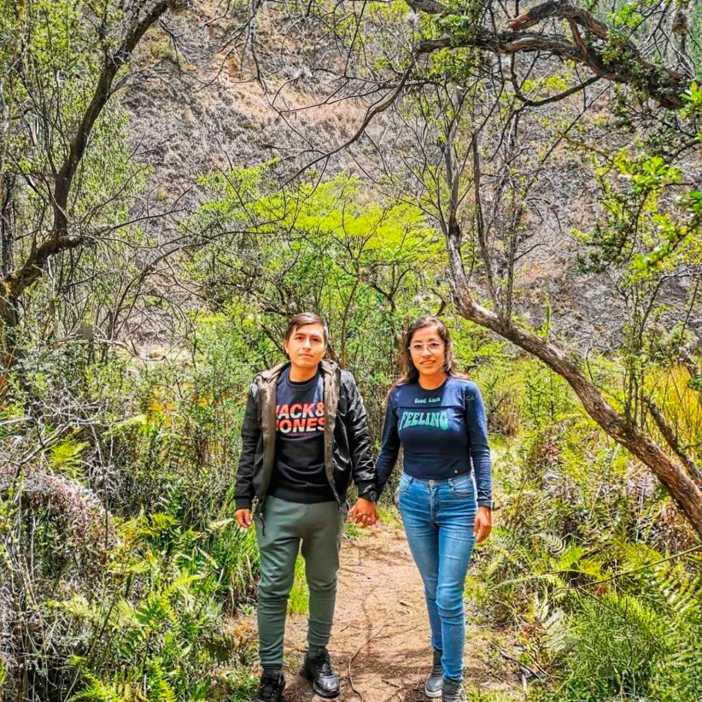 Pareja caminando por los senderos del Bosque del Amor en Vilca, rodeados de vegetación andina