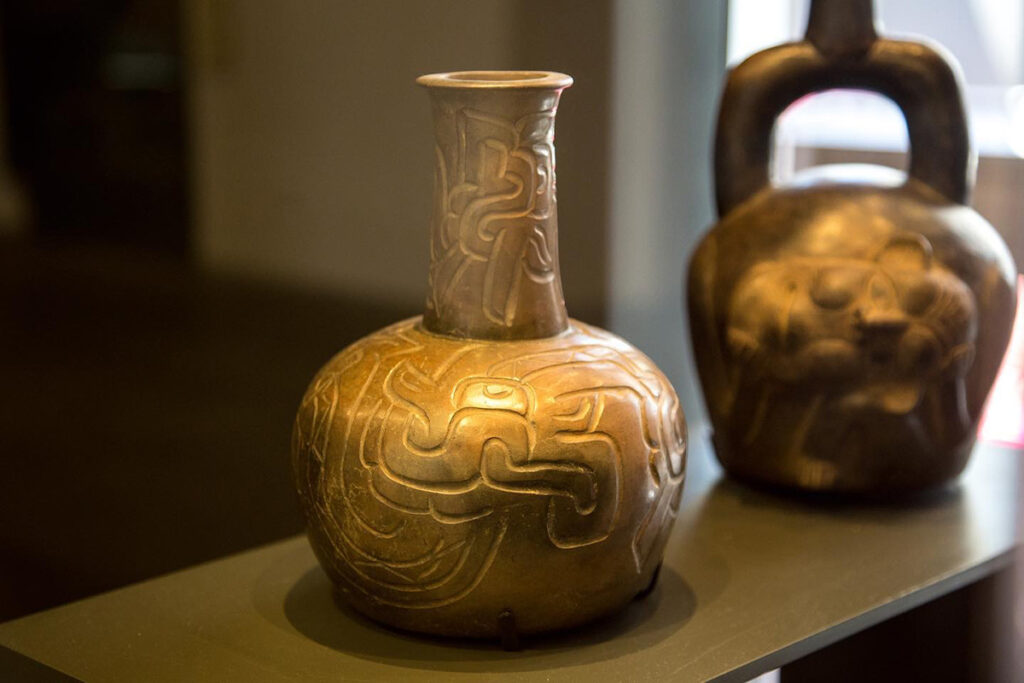 Vasija cerámica Chavín con relieves incisos y motivos híbridos, representativa del arte ritual y la iconografía preincaica de los Andes centrales