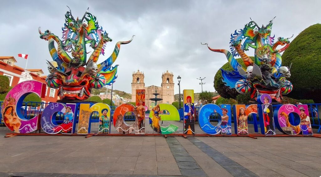 Esculturas de diablos y letrero de Candelaria en la plaza principal de Puno, símbolo del turismo cultural asociado a la Festividad de la Virgen de la Candelaria