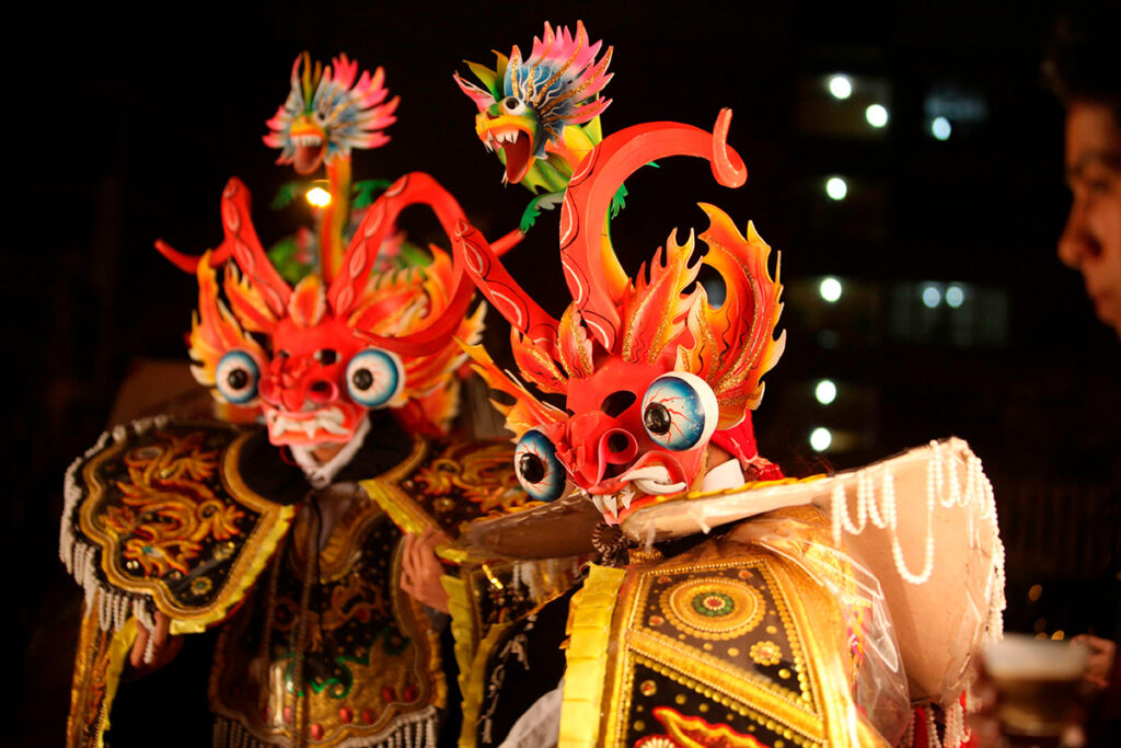 Máscaras tradicionales de la diablada puneña con detalles de serpientes, fuego y bordados dorados durante la Festividad de la Virgen de la Candelaria en Puno