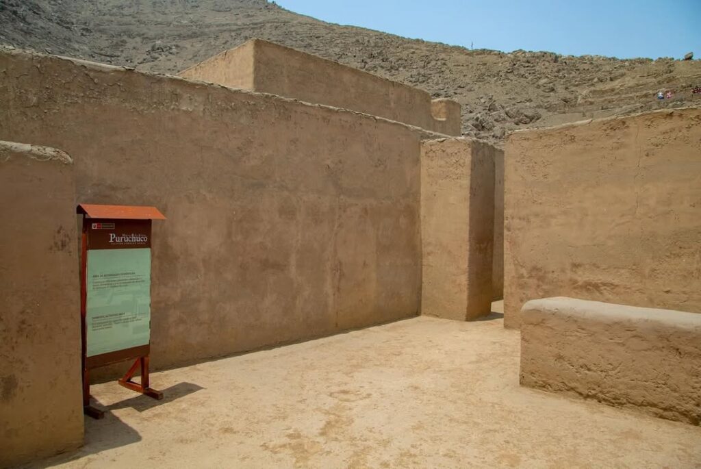Patios y muros de adobe restaurados en el complejo arqueológico de Puruchuco, con la ladera del cerro al fondo