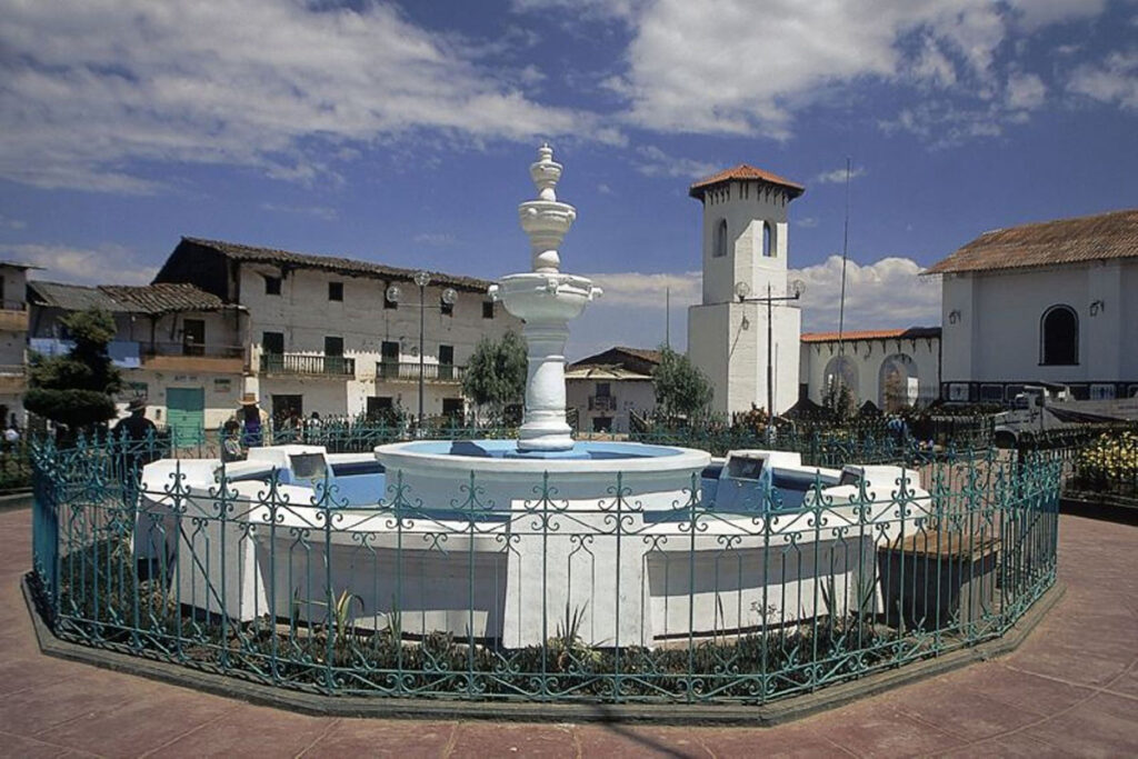 Plaza central de Santiago de Chuco con su fuente y edificaciones tradicionales alrededor, en un entorno urbano andino