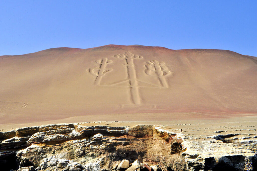 Geoglifo del Candelabro de Paracas trazado en una ladera arenosa frente al océano Pacífico, en la costa sur del Perú