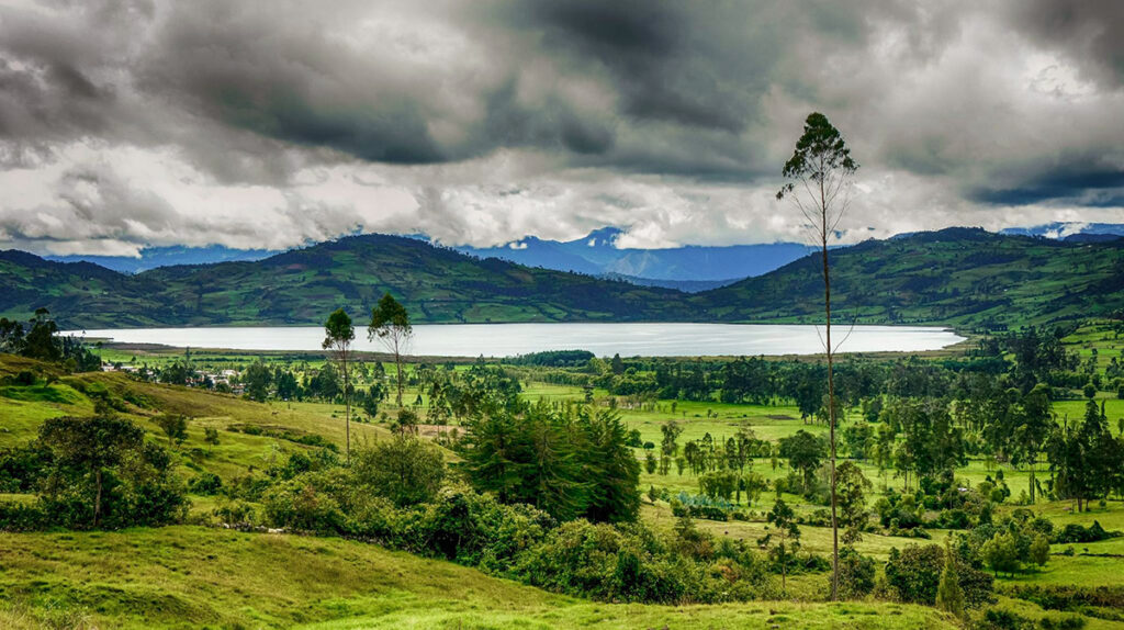 Vista panorámica de la laguna Pomacochas, en la región Amazonas, rodeada de colinas verdes y paisaje rural de la selva alta peruana