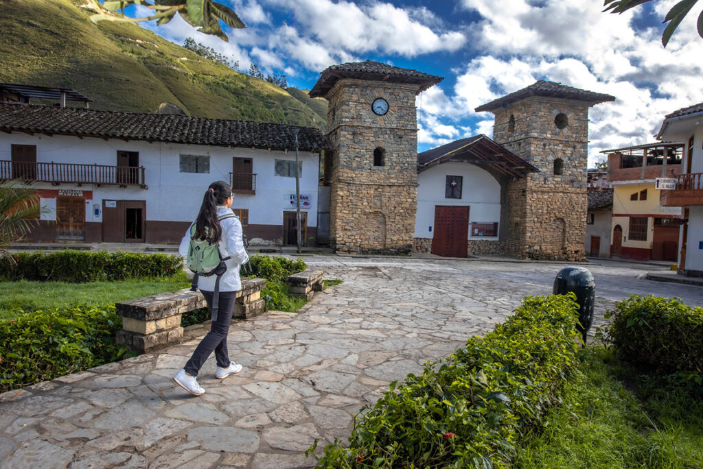 Plaza principal de Leymebamba, en la región Amazonas, con torres de piedra y viviendas tradicionales andinas en un entorno rural y tranquilo