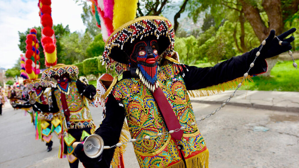 Danzantes de Los Negritos de Huánuco recorriendo las calles durante el ciclo navideño, con vestimenta bordada, máscaras y elementos rituales
