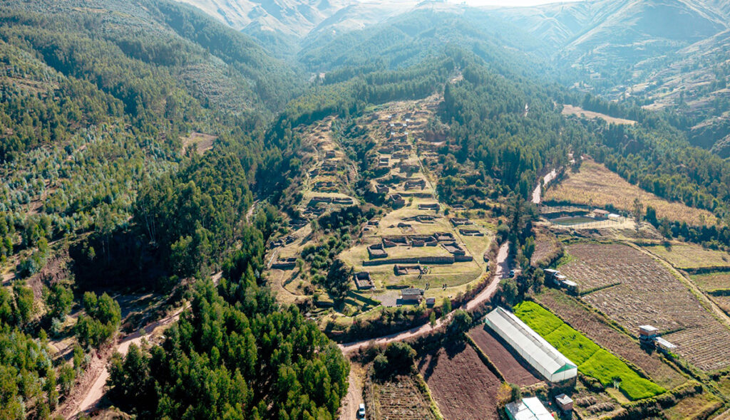 A vista de dron del asentamiento inca de Raqayraqayniyuq, con recintos, terrazas y áreas agrícolas rodeadas de bosque en Cusco