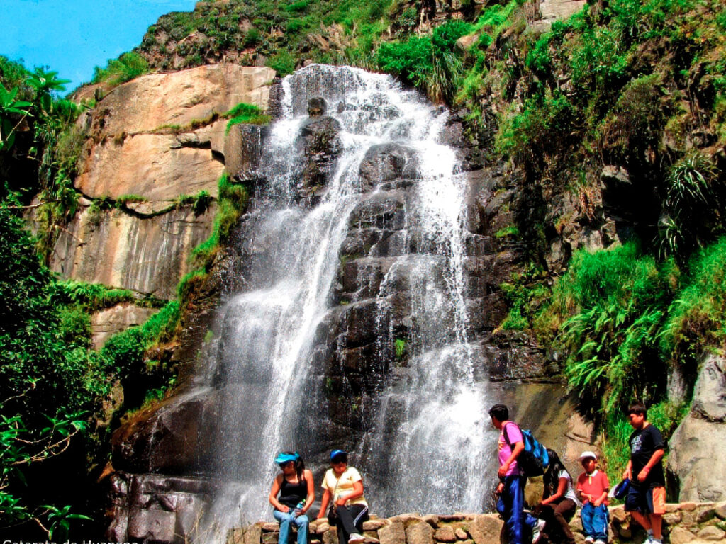 Catarata Huanano en San Jerónimo de Surco, Huarochirí, con visitantes descansando frente a la caída de agua en un entorno andino cercano a Lima