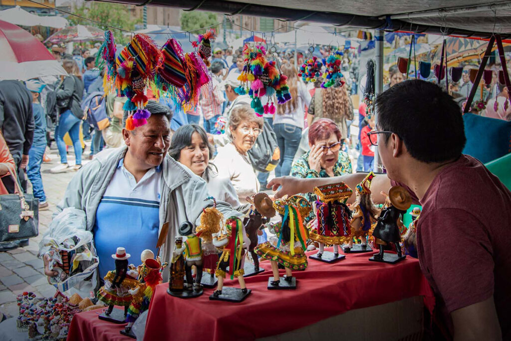 Feria del Santurantikuy en la Plaza Mayor de Cusco, con artesanos y familias comprando figuras para el nacimiento en la víspera de Navidad