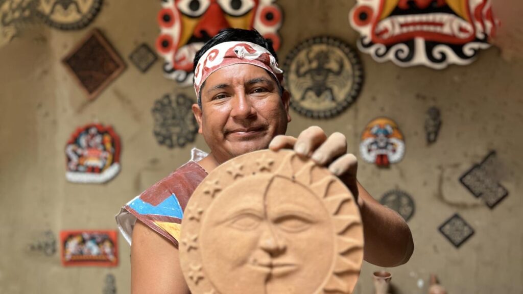 Artesano mochica mostrando una pieza de cerámica en proceso dentro de un taller artesanal en Trujillo