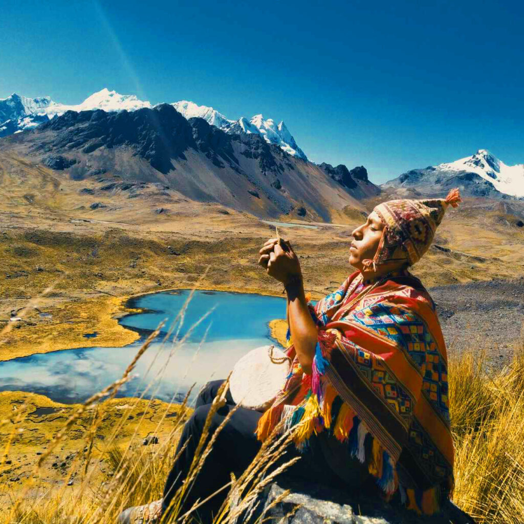 Chamán andino cerca de una Laguna. Chamán realiza pago a la tierra en laguna.